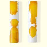 Two gourmet chocolate bars side by side hand-painted with cocoa butter in white and yellow. Handmade chocolate candy bars by online chocolate store Topogato.