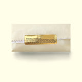 A sweet treat wrapped up for chocolate delivery in a cream sleeve from online chocolate store Topogato shown from the top down with a gold nutrition label.