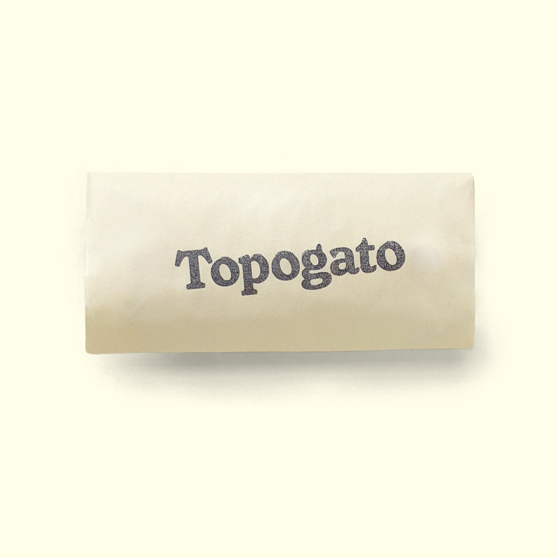 A sweet treat wrapped up for chocolate delivery in a cream sleeve with a logo of gourmet chocolate company Topogato shown from the top down.