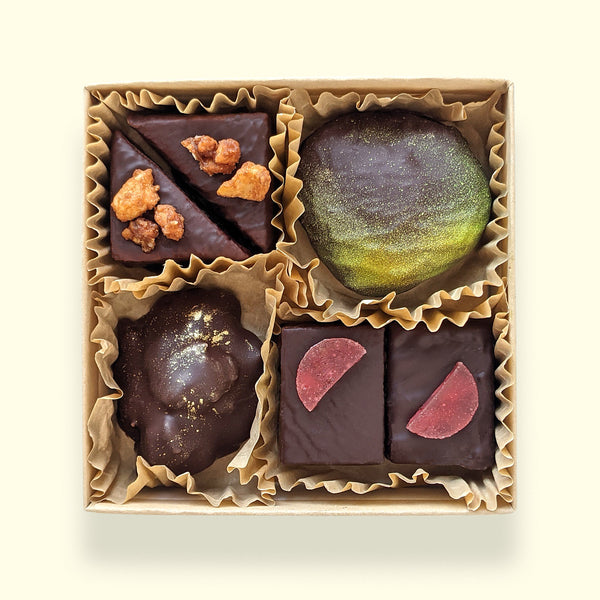 A gourmet chocolate box shown from the top down with assorted handmade chocolate treats from San Francisco chocolate store Topogato.