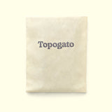 A handmade chocolate bar wrapped up for chocolate delivery in a cream sleeve with a logo of gourmet chocolate company Topogato shown from the top down.