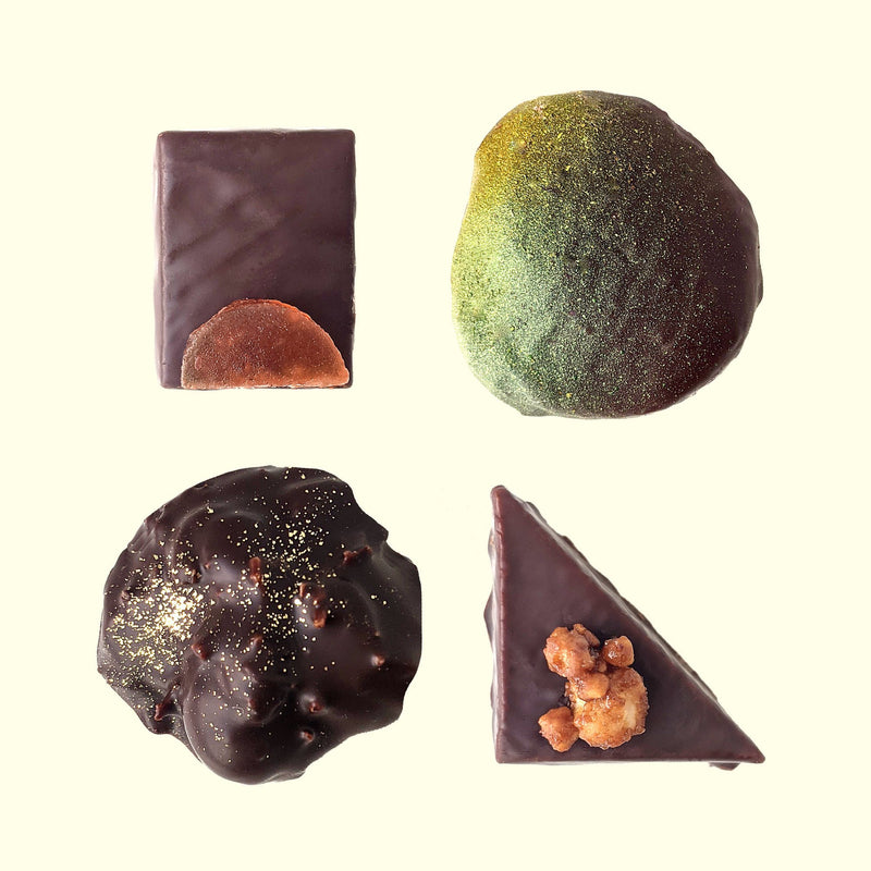 A top-down view of four pieces of colorful handmade chocolate from San Francisco chocolate company Topogato.